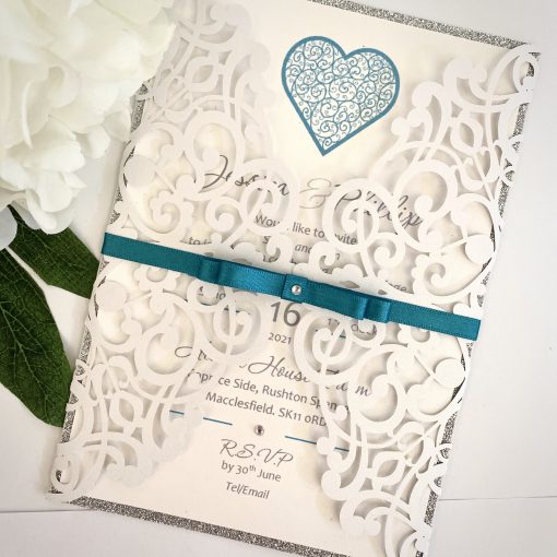 Crisp white laser cut invitation with teal dior bow detail